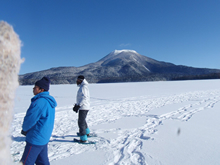 完全結氷した湖上の雪原をスノーシューで歩く