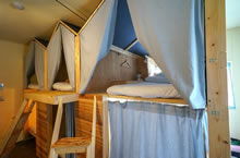 ドミトリーのベッドもオリジナル仕様。各ベッドに貴重品ボックスや小さな扇風機もある
