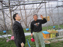 飯野農園を訪れるEVI推進協議会の加藤孝一と、農園主の飯野宣久さん。