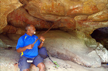 出産のための洞穴に描かれた壁画を説明するアボリジニの長
