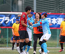 ブラインドサッカーは、視覚障がい者と健常者が混ざり合って行うスポーツである（左から、ゴールキーパー、オレンジのビブスを着たガイドを挟んでフィールドプレイヤー2人）（© JBFA/H.Wanibe）